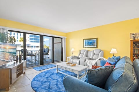 This sun-filled living room opens to the balcony and brings in all the beachy vibes with cozy seating and natural light.