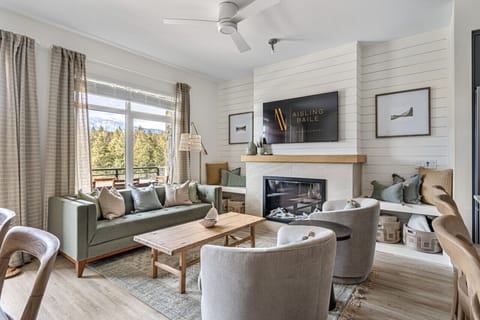 Main floor living room with a fireplace, cozy seating options, a Smart TV and walkout access to the balcony.