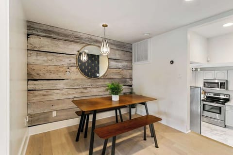 Cozy dining nook with rustic wood accent wall, bench seating, and modern lighting. A stylish spot to enjoy meals at home, just steps from the kitchen and living areas.