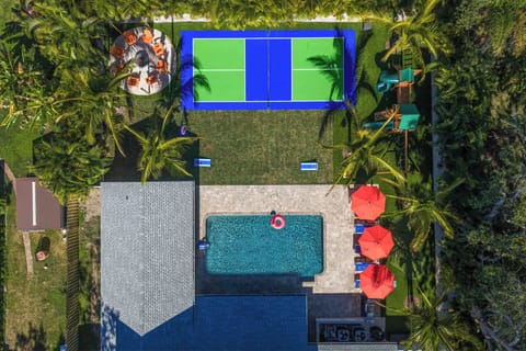 Backyard Paradise: Dive into fun with a pool, tennis court, and vibrant seating for all!