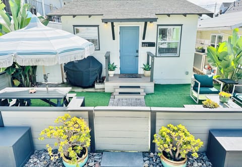 Front yard with picnic table, grill, and lounge set.