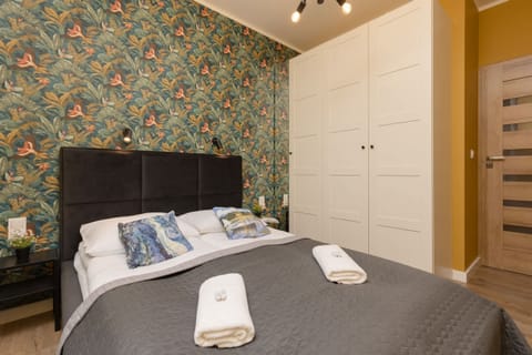 A cozy bedroom featuring a comfortable bed with soft linens and a stylish accent wall.
