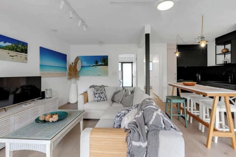 The living area offers an oversized L-shaped lounge to relax on in front of the TV.