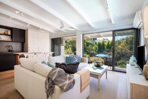 The living area offers an oversized L-shaped lounge to relax on in front of the TV.