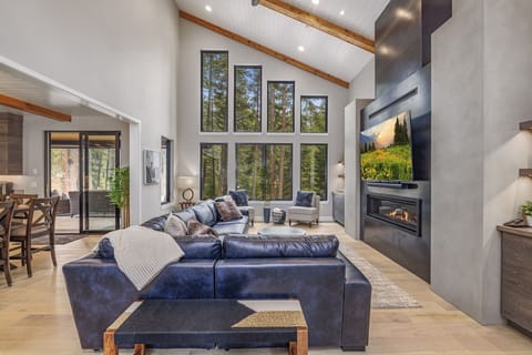 Spacious Living Room With Custom Hearth, Designer Lighting + Seamless Dining Flow