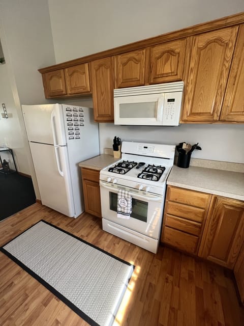 Fully stocked kitchen with full refrigerator, gas stove/oven, microwave