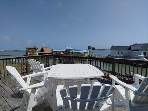 Relax on your private deck with waterfront views, where white Adirondack chairs invite morning coffee moments and sunset conversations by the water.