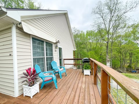 The side balcony features a grilling area and comfortable chairs with a view of the lake