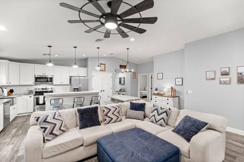 Bright, open-concept living area with plush sectional seating and modern kitchen—perfect for relaxin