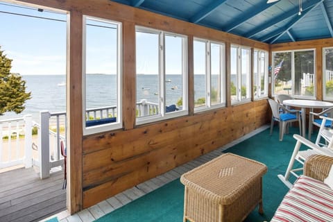 Oceanfront views from screened porch with outdoor dining and lunge furniture