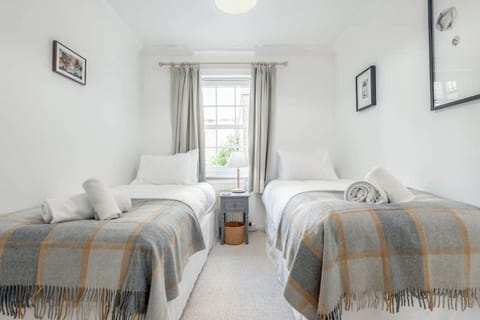 Bright bedroom at 6 Abbey Street featuring two comfortable single beds, ideal for friends or family sharing.