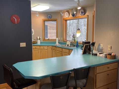 Kitchen, looking in from dining area. Three chairs on island