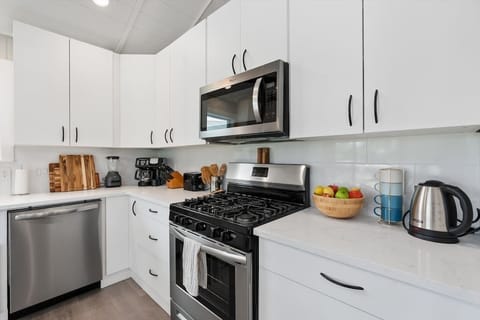 The kitchen comes fully stocked with cooking appliances & utensils.