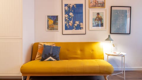 Unwind on the vibrant yellow sofa, surrounded by eclectic art, perfect for an evening of relaxation with a good book.
#LivingRoom #ColorfulDecor #LovelyStay