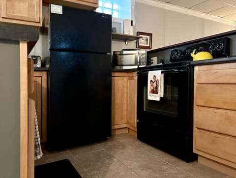 Full kitchen stocked with spices, utensils, pots and pans.