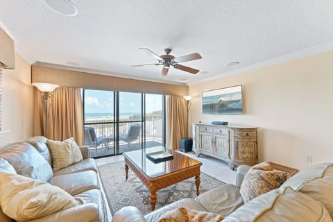 Unwind in the cozy living room while enjoying stunning beach views from the balcony.