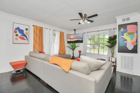Sunlit living room with 55-inch Roku TV, super comfortable deep couch