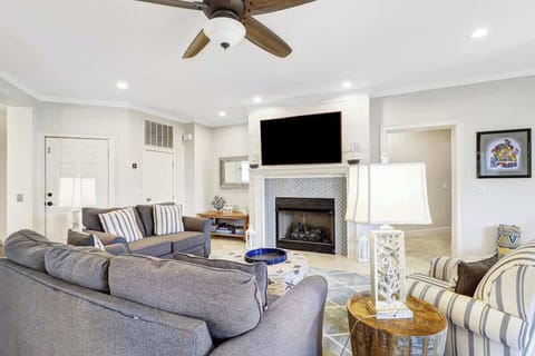 Unwind in your elegant living room with cozy seating, flickering fireplace, and ceiling fan keeping you perfectly comfortable.