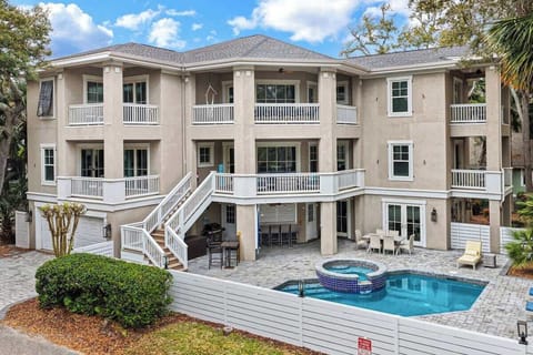 This elegant three-story coastal home features multiple balconies, a private pool with spa, and tropical landscaping for the perfect vacation retreat.