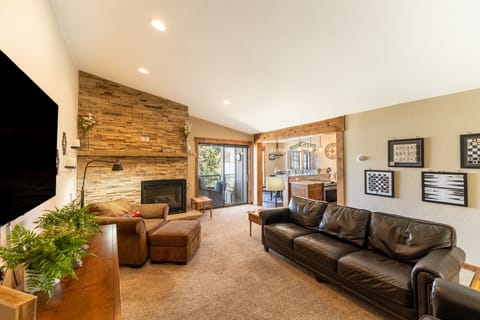 Sink into plush leather seating by your stone fireplace, where warm lighting and rustic charm create the perfect spot to unwind.