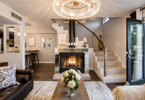 From the living room, enjoy a clear view of the stairs leading to the loft space, complemented by a cozy fireplace and a large smart TV, creating a perfect blend of comfort and style.