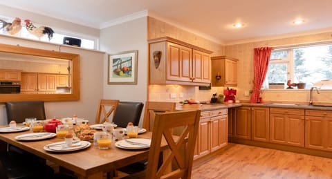 Four Pines Lodge dining table set for breakfast with kitchen