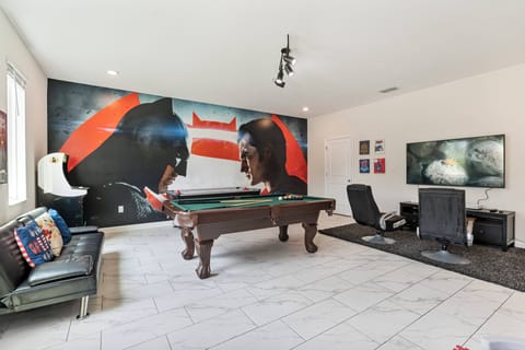 Invite your friends to enjoy this lively game room, complete with a stylish pool table and vibrant mural. The sleek black leather sofa and modern gaming setup provide an ideal space for fun and relaxation together.
