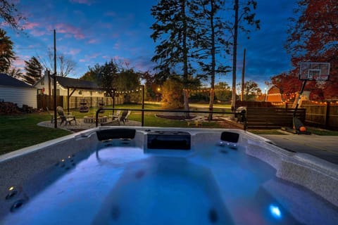 The photo doesn't do the size of this hot tub justice...COMFORTABLY fits 10! Look out onto the firepit, bbq deck and basketball court while relaxing