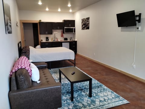 Grewingk Suite. Equipped with queen bed, kitchenette, sofa, 32 inch smart TV, and, dining area.