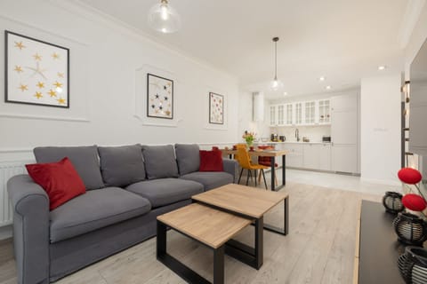 A modern living room with a grey sofa, a wooden coffee table, and stylish decor, creating a cozy yet sophisticated space.

