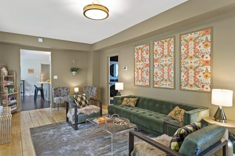 Living room with comfortable seating areas, large screen TV, and record player.