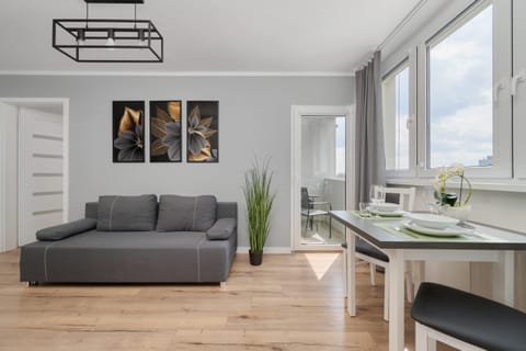 A stylish living room with a gray sofa, wooden coffee table, and modern decor, including vibrant wall art.
