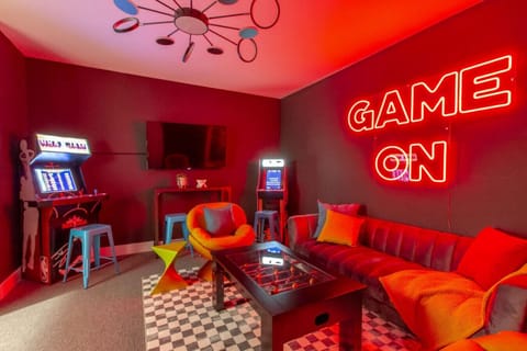 Vibrant game room with a `GAME ON` neon sign, arcade machine, and colorful retro seating