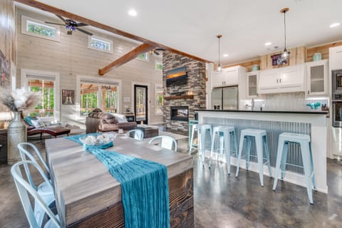 Open kitchen and dining with stone fireplace and modern finishes