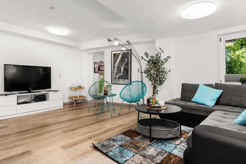 In dem Wohnzimmer befindet sich eine große Couch, welche zu einem Schlafsofa umfunktioniert werden kann. Hier finden 1-2 Gäste Platz zum Schlafen. Ebenso steht ein TV zur Verfügung, auf dem Magenta TV und diverse Streaming Apps installiert sind.