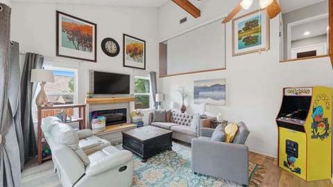 The open living room boasts plenty of seating for the whole crew as well as a stand-up Pac Man Arcade game.