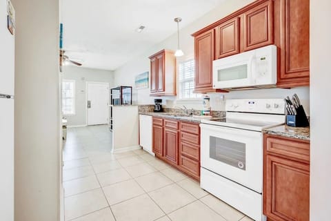 Full kitchen with wood cabinets and white appliances