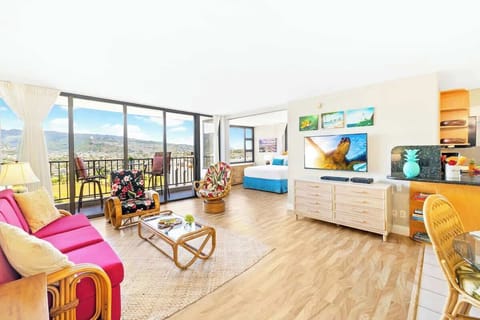 This vibrantly decorated condo features a living area with a pull-out sleeper sofa, a 51" Smart TV, and direct access to a balcony offering expansive mountain and city views.