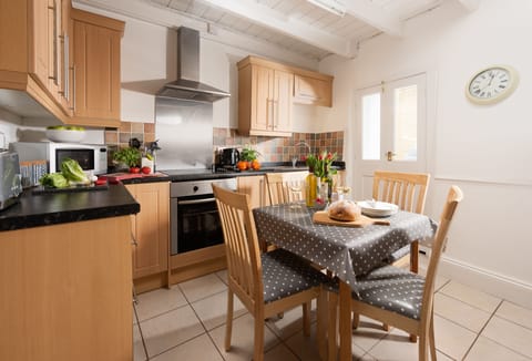 The well equipped kitchen with electric oven and hob, fridge/freezer, microwave and dining table for four.