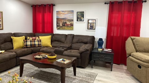 Open concept living room with large sectional 2 chairs and recliner