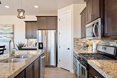 Kitchen Side View - Side view of kitchen showing off the beautiful counter tops and stainless-steel appliances.