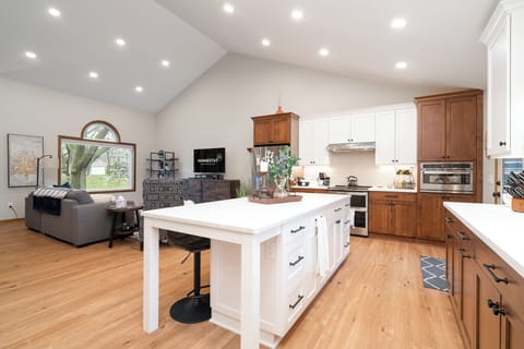 Cook and gather in your spacious open-concept kitchen with warm wood cabinetry, granite island, and cozy living area.