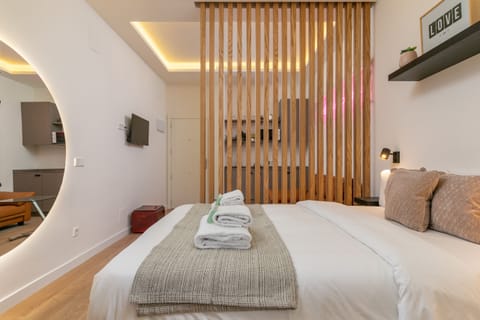 View of the bed area and kitchen in the background