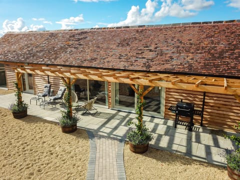 Large patio with sun loungers, picnic bench and BBQ