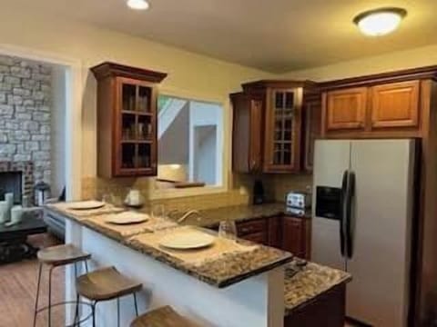 Kitchen is appointed with glassware, silverware, cooking utensils, plates to service 16, microwave, glass top electric range/oven, ice maker, toaster, blender, can opener, Please contact host if you would like to use charges and table linens.