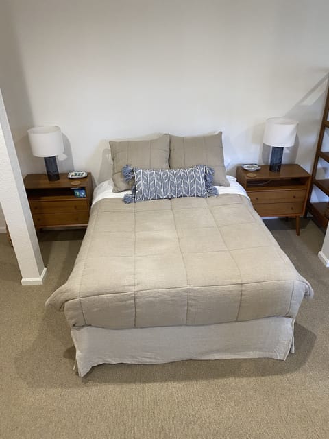 The queen bed has a television next to it.