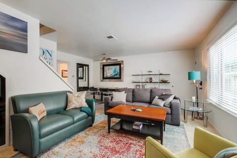 Open living space with comfortable couches, board games, indoor wood-burning fireplace, smart TV and dining area