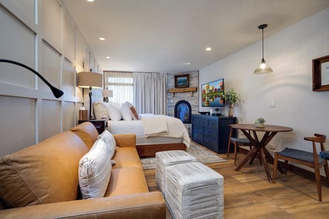 Unwind in this beautifully designed studio where your cozy leather sofa faces a crackling fireplace, creating the perfect spot for evening relaxation.