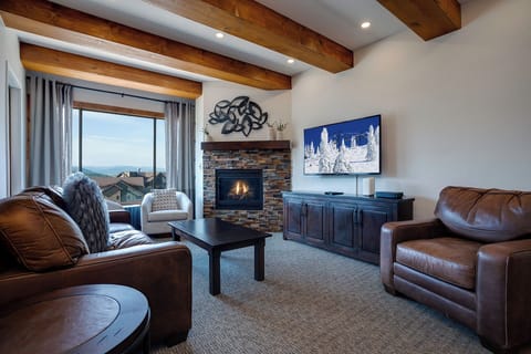 Curl up in sumptuous leather seating by the crackling fireplace while soaking in stunning mountain views through expansive windows.