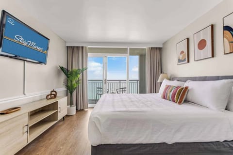 Wake up to panoramic ocean views in this serene bedroom featuring a plush king-size bed, stylish décor, and balcony access. Perfect for unwinding after a day of beach adventures!